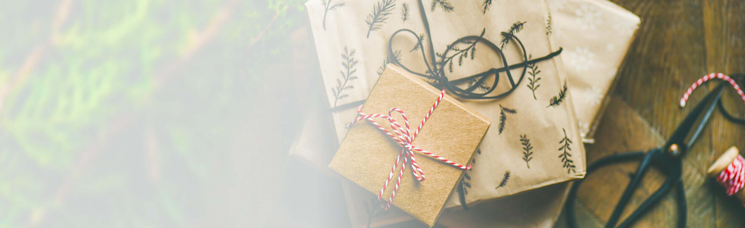 A pile of Christmas gifts wrapped in brown paper and different coloured string