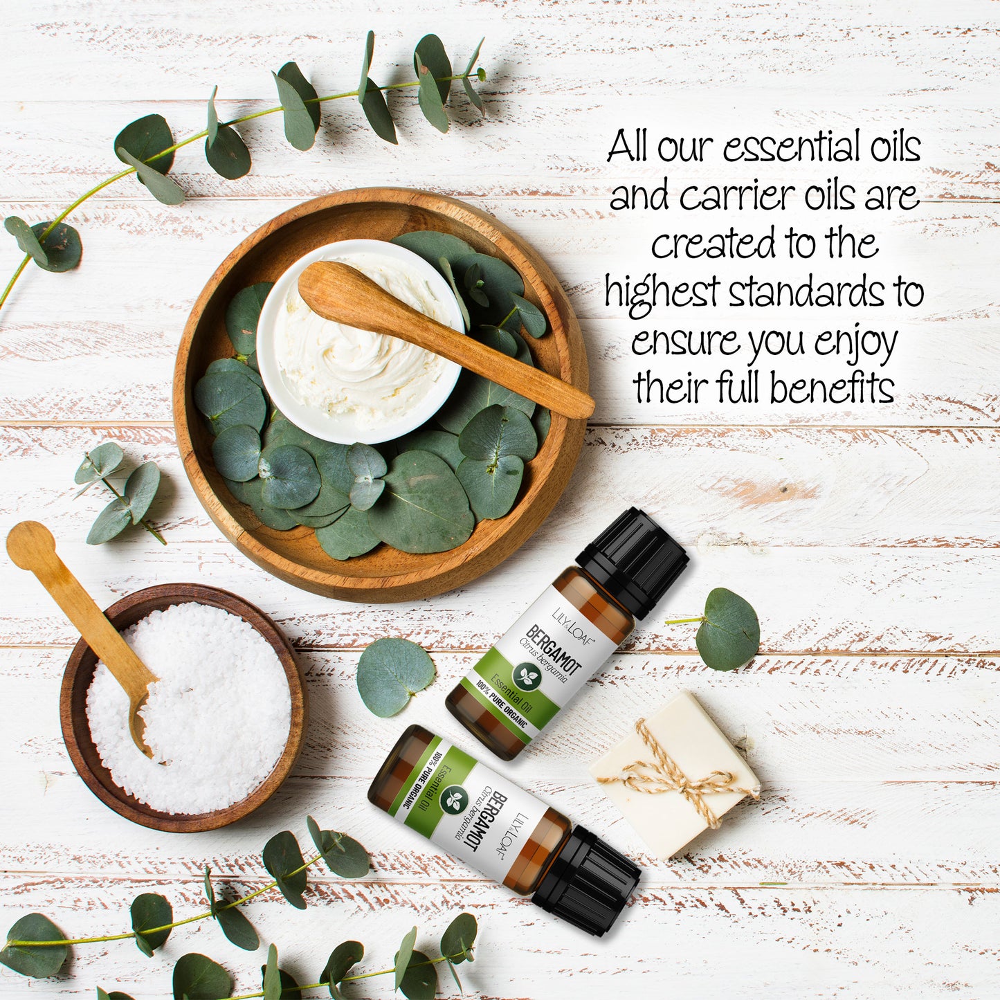 Lily & Loaf Organic Bergamot Essential Oil bottle next to a wooden bowls filled with creams creating a refreshing and inspiring spa experience.