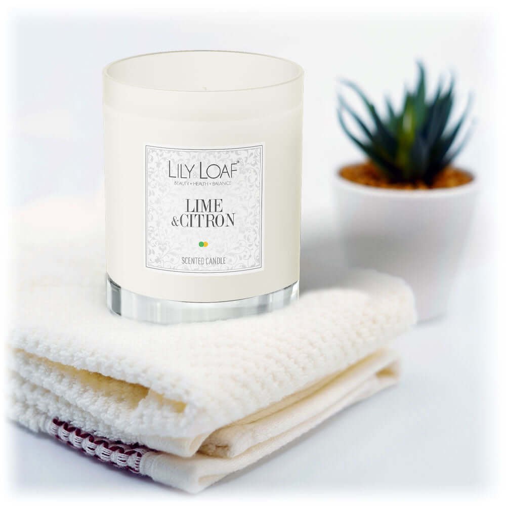 Lily & Loaf Lime & Citron Soy Wax Candle resting on white towels