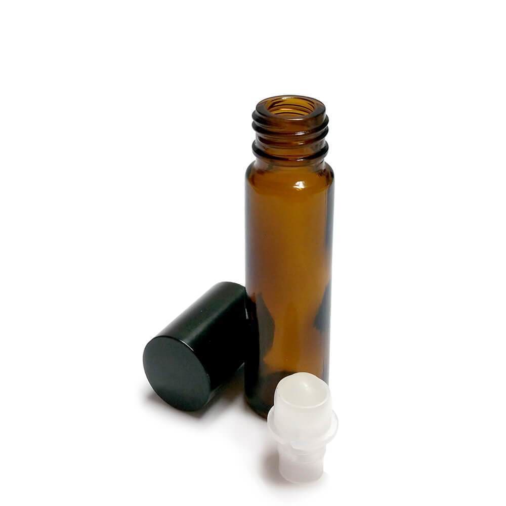 10ml amber glass rollerball bottle with black cap removed, and clear rollerball applicator lying beside bottle.