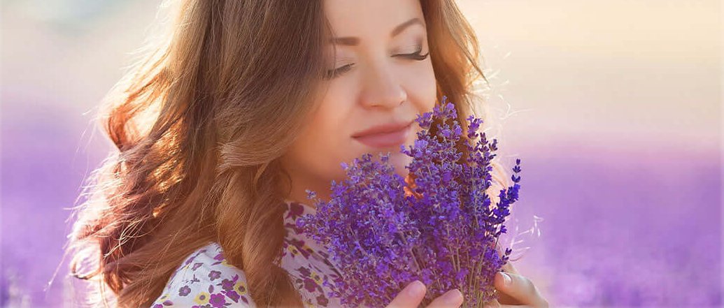 Woman inhales the natural fragrance of lavender, Lily & Loaf's essence for calm and relaxation.