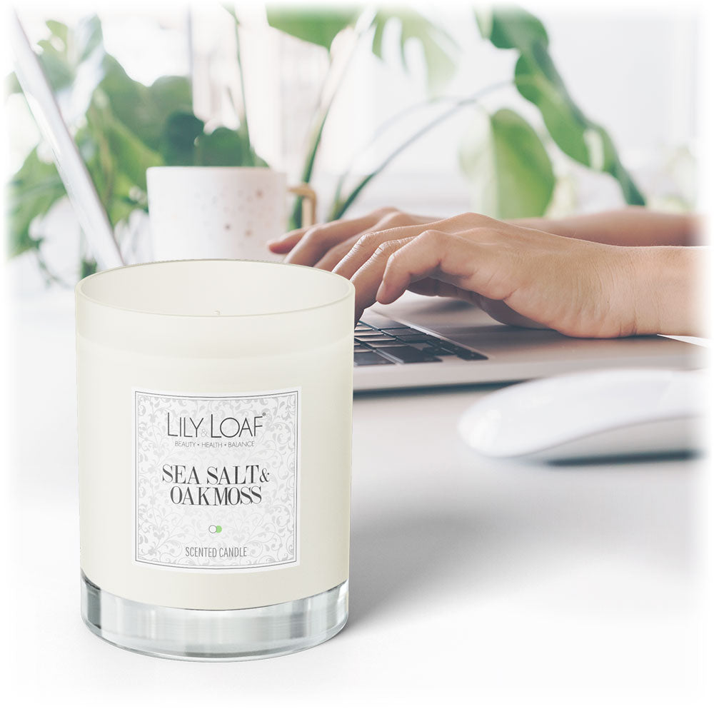 Lily & Loaf Sea Salt & Oakmoss Soy Wax Candle on a home office desk with a laptop and coffee in the background