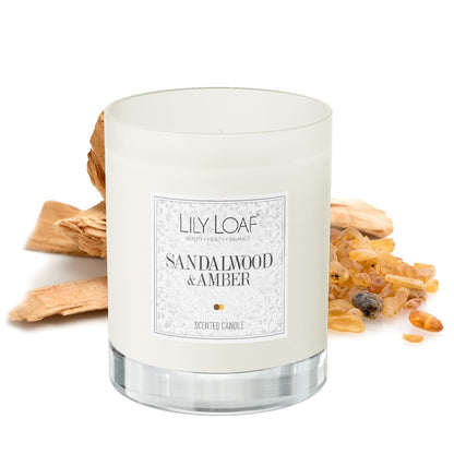 Sandalwood and Amber Soy Wax Candle with ingredients behind