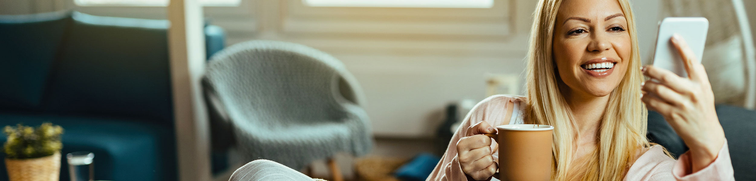 A woman relaxing with a coffee whilst shopping on her phone